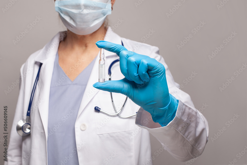 Hand of a lab technician or medical doctor holding ampoule close up Hand of a lab technician or medical doctor holding ampoule close up