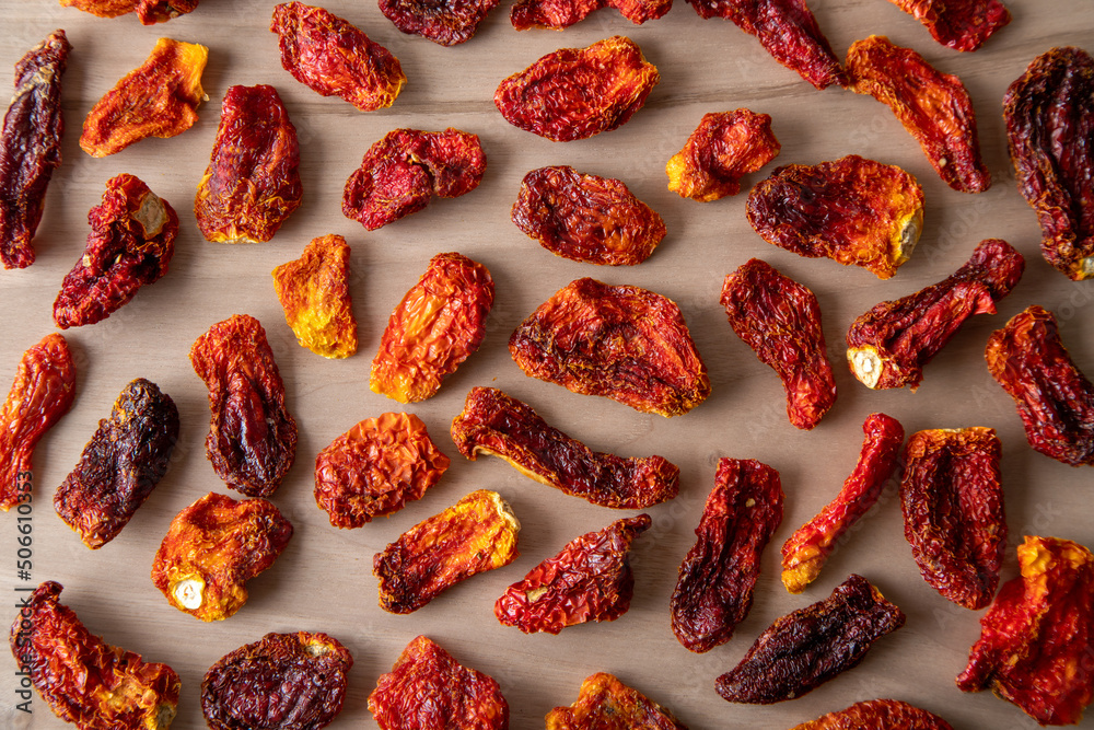 Slices of sun-dried tomatoes on wooden background
Slices of sun-dried tomatoes on wooden background
