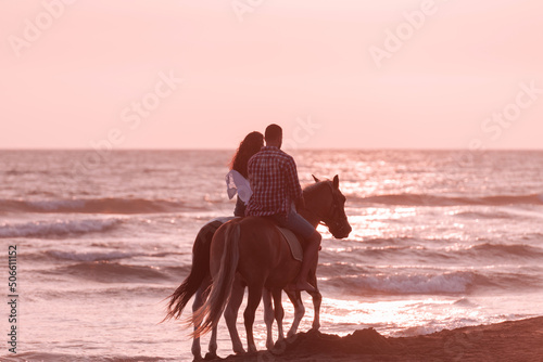 The family spends time with their children while riding horses together on a sandy beach. Selective focus 