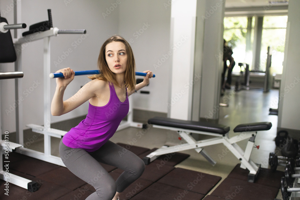 The girl is engaged in fitness in the gym. Playing sports in the gym. A set of exercises for the back. Women's health. Weight loss and a healthy body. The girl is engaged in fitness in the gym. Playing sports in the gym. A set of exercises for the back. Women's health. Weight loss and a healthy body.