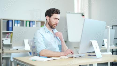 Casual businessman sitting at desk hot in the workplace, no air conditioning. Male office worker suffering from heat sweaty wipes his forehead. a man at work. summer hot weather. Indoor