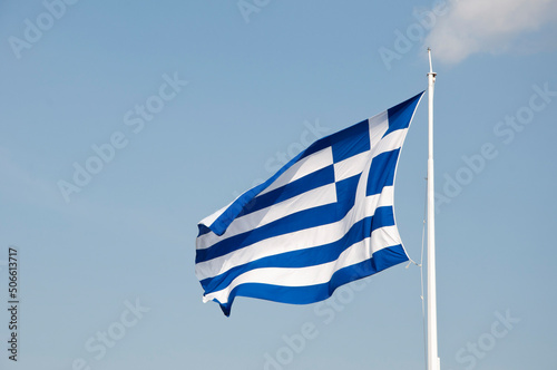 National Greek flag of Hellenik republic emblem waving on flagpole sky background