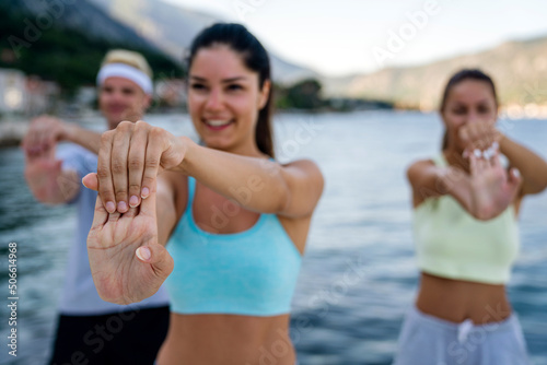 Group of cheerful fit fitness friends team exercising together outdoor. Sport people concept