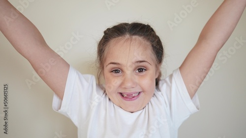 portrait child girl looking at the camera. happy indoors family kid dream concept. baby eyes down then look at the camera and smiles. funny portrait girl kid close-up. smile teeth fell out