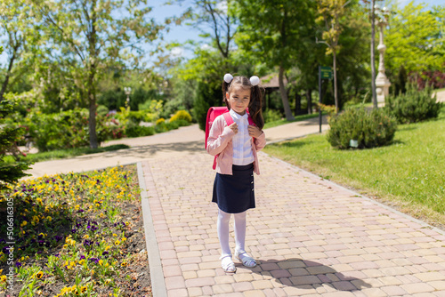 Fototapeta Naklejka Na Ścianę i Meble -  Back to school. Happy smiling kid go to elementary school. Child with school bag outdoors