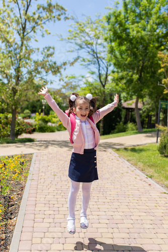 Back to school. Happy smiling kid go to elementary school. Child with school bag outdoors