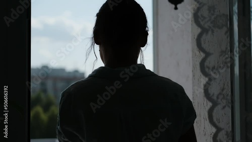 Young woman goes to balcony and look at the city