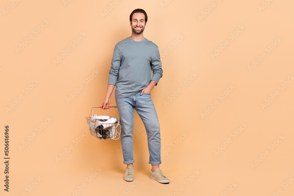 Fototapeta premium Full size photo of young cheerful man shop purchase discount supermarket isolated over beige color background