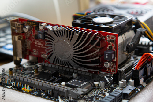 red video card with a passive cooler on a laboratory bench in a computer motherboard