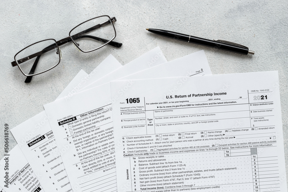 US individual tax form with pen and glasses on businessman table US individual tax form with pen and glasses on businessman table