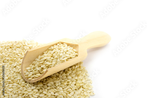 Sesame seeds and wood spoon in white