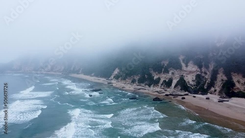 Aerial drone shot of a misty ocean shoreline in Sedgefield, a popular travel destination along the Garden Route in the Western Cape, South Africa photo