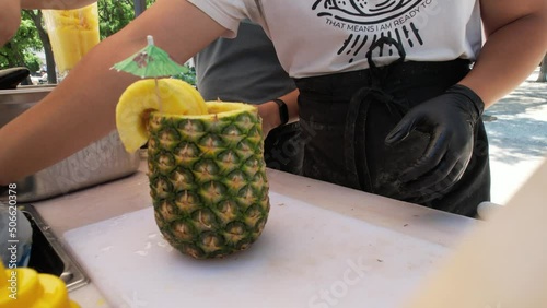 A street juice vendor embellish a pineapple at Lisbon,Portugal
