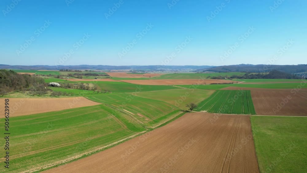 Aerial view over colorful, growing, spring fields in Germany - rising, drone shot Aerial view over colorful, growing, spring fields in Germany - rising, drone shot