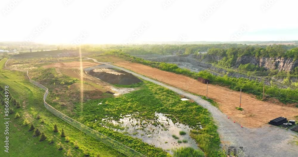 Rising aerial view of rural America. Sunlight shines onto lens and creates lens flare. Sunset over quarry in USA. Rising aerial view of rural America. Sunlight shines onto lens and creates lens flare. Sunset over quarry in USA.