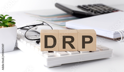 DRP Disaster Recovery Plan written on a wooden cube on the keyboard with office tools photo