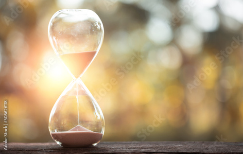 Принти на полотні hourglass (sand clock) on an old wooden table with natural blur background, Hour