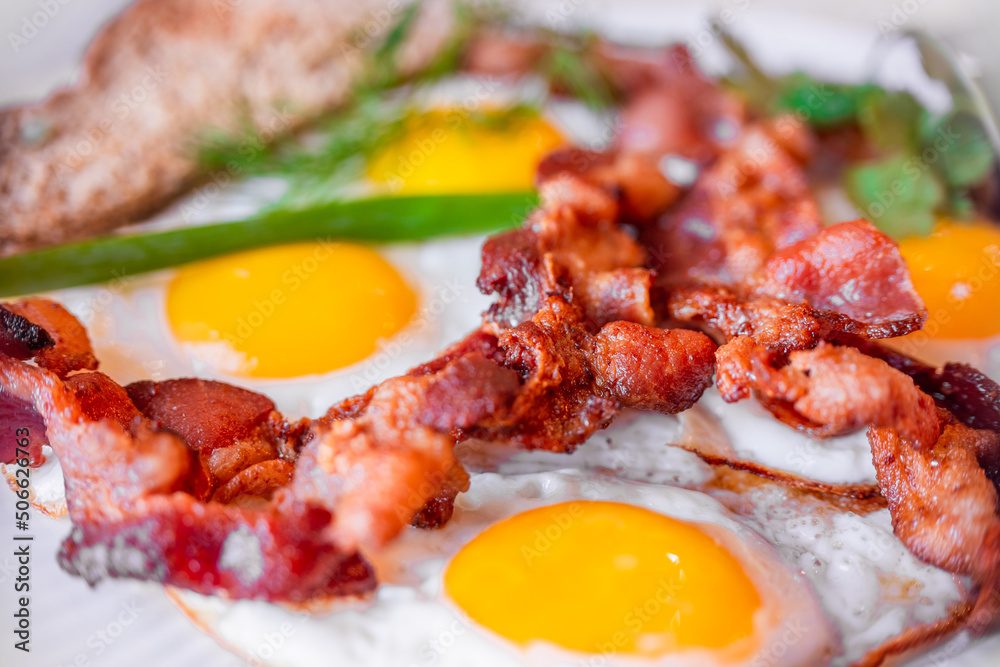 Tasty fried eggs eggs and crispy bacon, close-up, great classic breakfast. Macro photography, shallow depth of field. Tasty fried eggs eggs and crispy bacon, close-up, great classic breakfast. Macro photography, shallow depth of field.