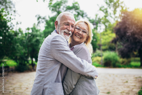 Senior active caucasian couple hugging looks happy in the park in the afternoon