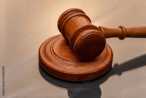 Foto Wooden judge's hammer on a gray background