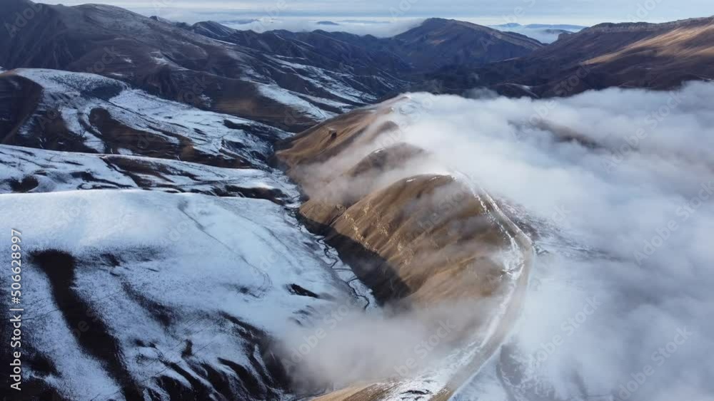 Dirty road on top of mountain in clouds, aerial view 4k Dirty road on top of mountain in clouds, aerial view 4k