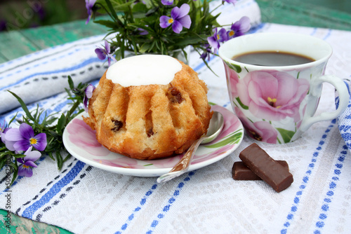 A couple of teas, a bouquet of violets and homemade dessert rum baba decorated with whipped cream