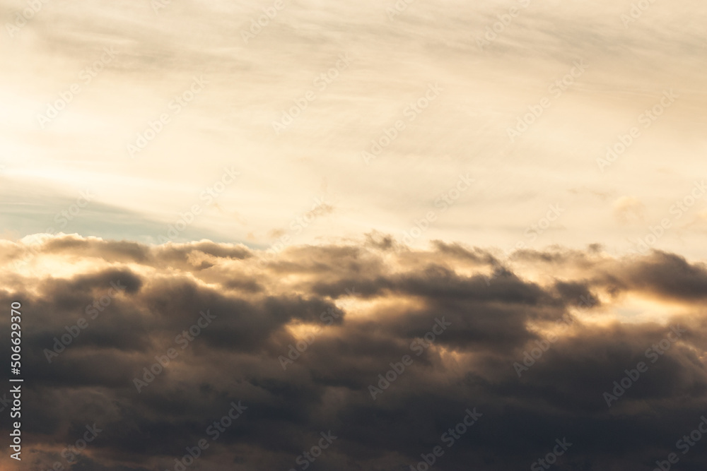 clouds on the sky in golden hour light. warm weather in summer at sunset