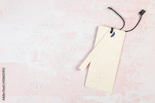 Clothing tag, label blank mockup template on a marble pink table