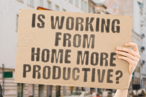 The question " Is working from home more productive?" is on a banner in men's hands with blurred background. Progress. Sofa. Resource. Remote. Energy. Capable. Improved. Increased. Internet. Result