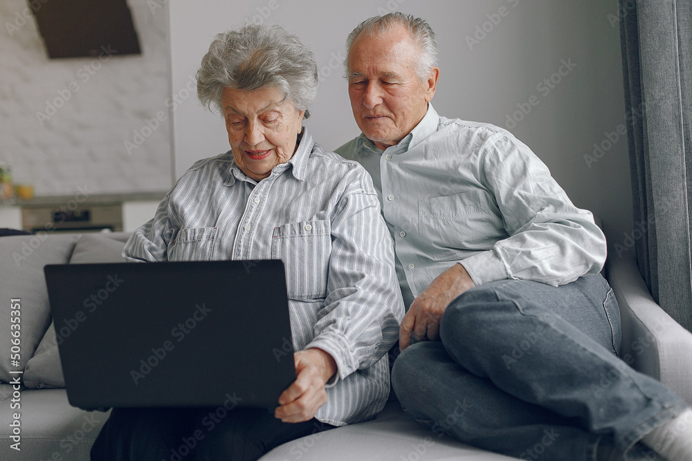 Elegant old couple sitting at home and using a laptop Elegant old couple sitting at home and using a laptop