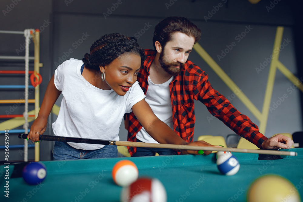 Fototapeta premium International couple playing a billiard in a club