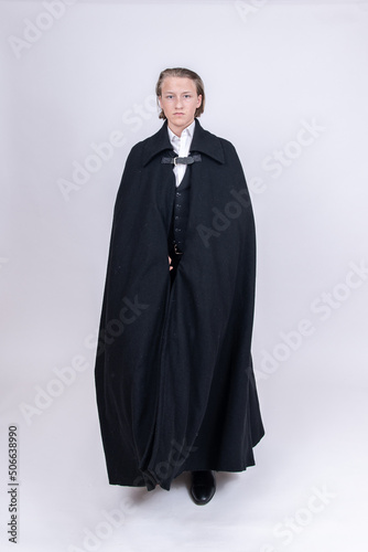 Junger Mann verhüllt mit schwarzem Mantel