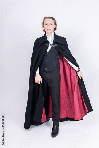Junger Mann im Anzug mit schwarzem Cape