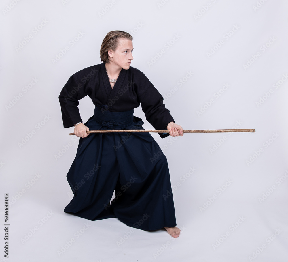 junger mann in traditionellem Kendo Gewand, Stock nach vorne