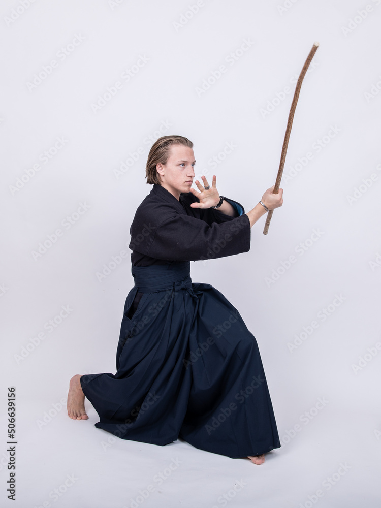 junger mann in traditionellem Kendo Gewand, Stock nach oben