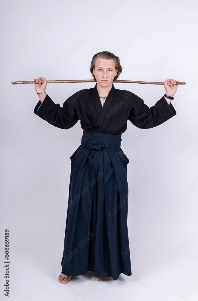 junger Mann in traditionellem Kendo Gewand mit Stock