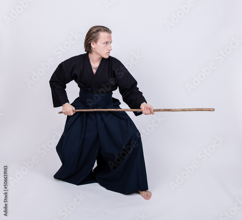 junger mann in traditionellem Kendo Gewand, Stock nach vorne