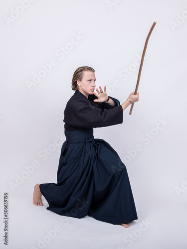 junger mann in traditionellem Kendo Gewand, Stock nach oben 