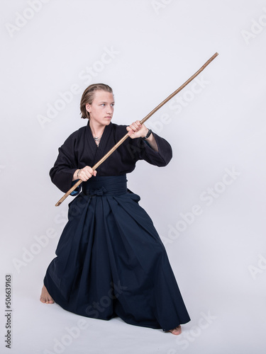 junger mann in traditionellem Kendo Gewand, Stock schräg nach oben