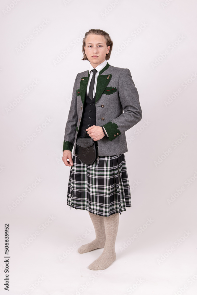 blonder, junger Mann trägt einen Kilt und eine Trachtenjacke