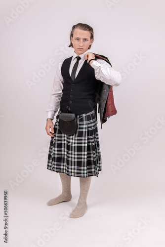 Obraz na płótnie blonder, junger Mann trägt einen Kilt und Trachtenjacke über der Schulter w salonie