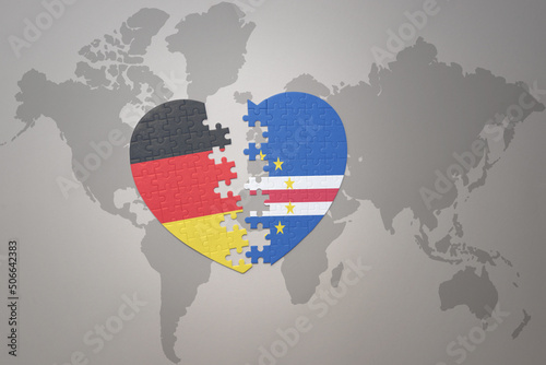 puzzle heart with the national flag of cape verde and germany on a world map background. Concept.