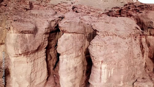 Tall Solomon Pillars in the eroded rocks of the Red Canyon in the dry Timna Park in the Negev Desert in southern Israel. Close-up lifting drone shot photo