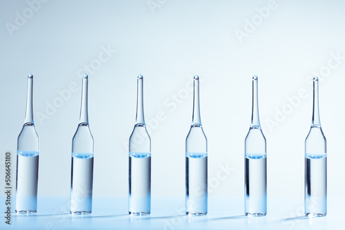 Six medicine ampules standing in a row. Blue monochrome medicine concept image.