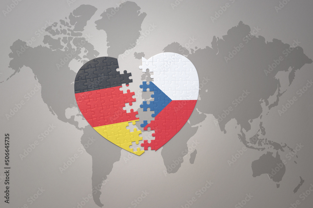 Obraz premium puzzle heart with the national flag of czech republic and germany on a world map background. Concept.