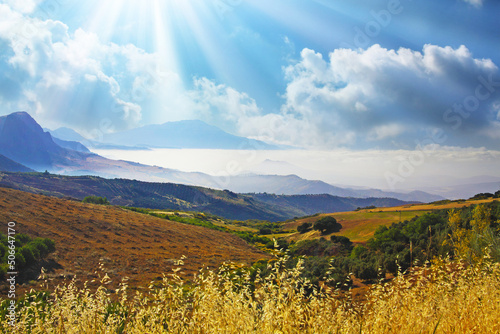 Typical quiet andalusian mountain valley morning scene, sea of low stratus clouds, agriculture fields, sun rays - Spain, Andalusia