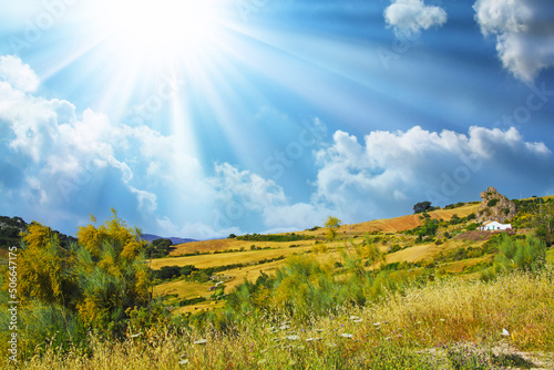 Typical andalusian calm mountain valley landscape, sun rays, low morning clouds, idyllic white farm house in rock front, agricultural fields - Spain, Andalusia, Montes de Malaga