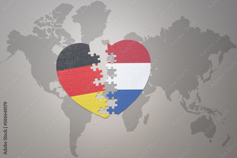 puzzle heart with the national flag of netherlands and germany on a world map background. Concept. - obrazy, fototapety, plakaty 