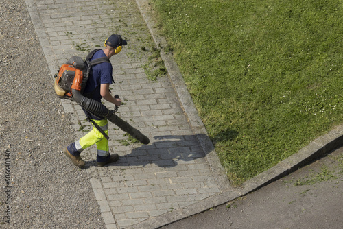 Jardinier en train de nettoyer une allée d'un espace vert
