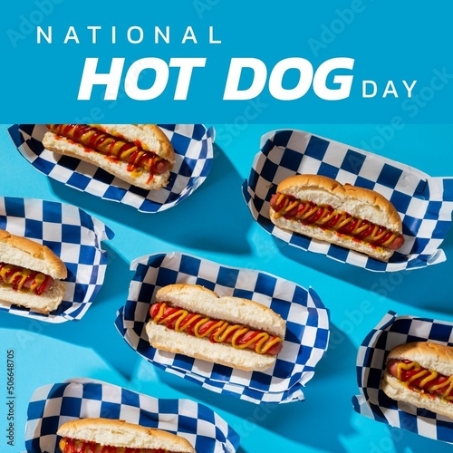 Composite of national hot dog day text with hot dogs in paper plate on blue background, copy space